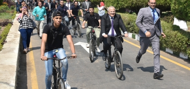 عثمان الخشت رئيس جامعة القاهرة خلال مشاركته مع الطلاب بماراثون الدراجات داخل الحرم الجامعى