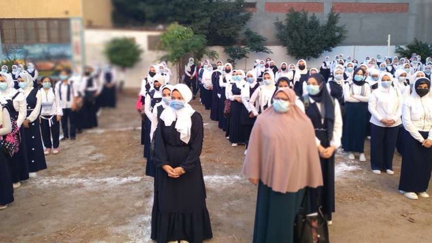 الطالبات يلتزمن بارتداء الكمامات الطبية أثناء طابور الصباح لمواجهة كورونا