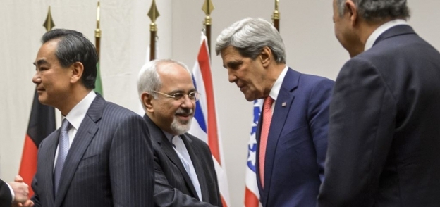محمد جواد ظريف يصافح وزير الخارجية الأمريكي السابق جون كيري
