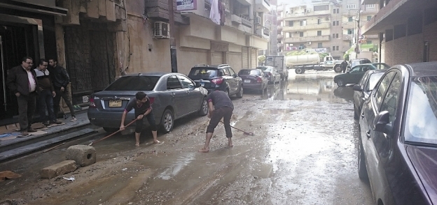 الأهالى أثناء تنظيف شوارع الغربية من مياه الأمطار