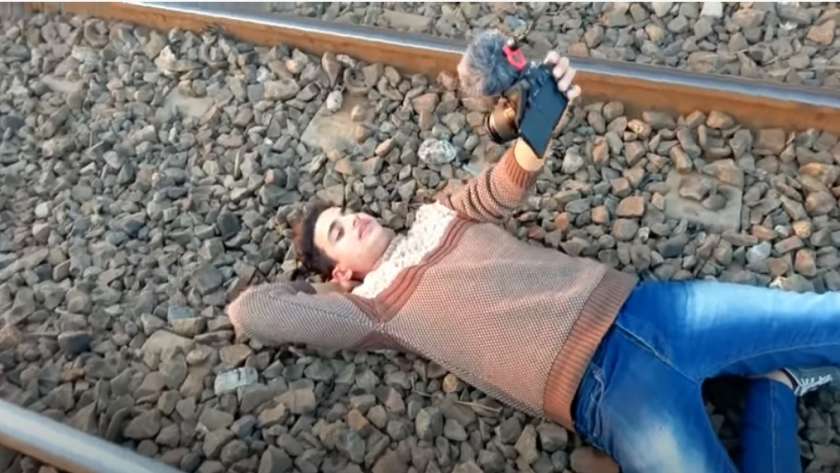 لقطة من الفيديو أثناء نوم شاب على أحد قضبان السكة الحديد