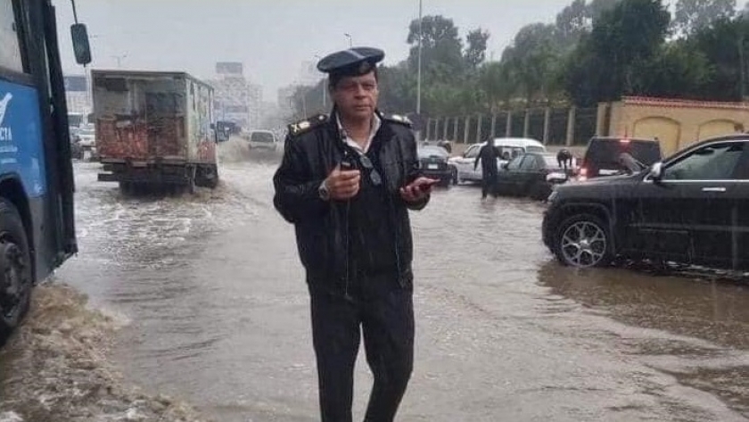 ضابط شرطة يقف وسط الأمطار