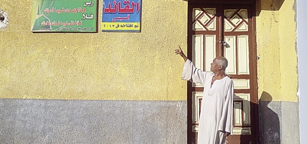 مواطن يشير إلى لافتة مسجد القائد بعد إغلاقه