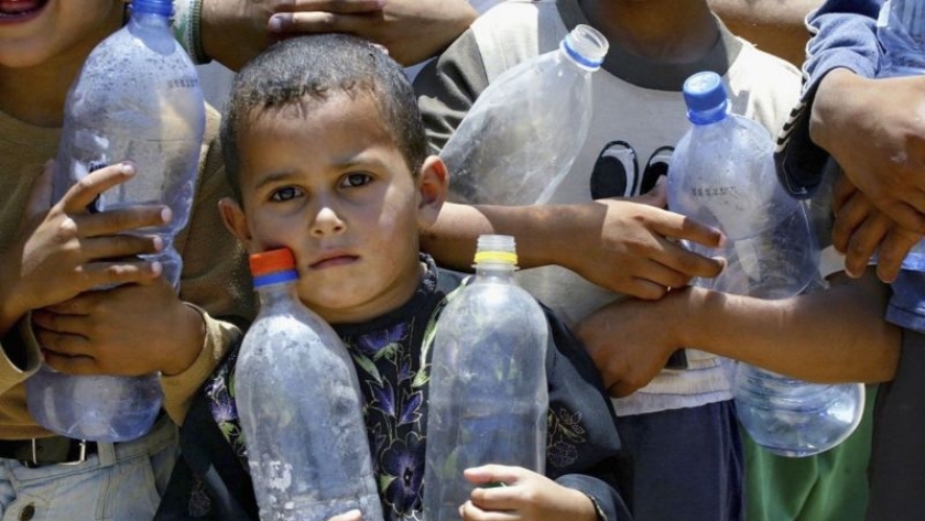 أطفال في غزة ينتظروا الحصول على مياه الشرب