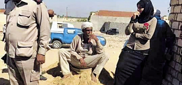 قوات الشرطة مع «منى» أثناء فتح الحفرة التى تم دفن الضحية وابنتها بها
