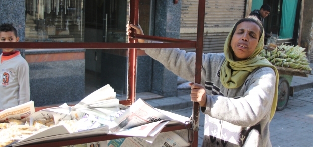 «أم رشا» تبيع الصحف والمسليات فى شارع المعز