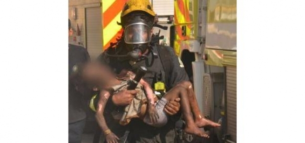 أحد فريق الإنقاذ حاملا طفل