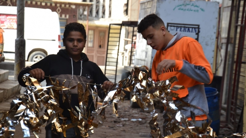 الأطفال يعلقون زينة رمضان في الشوارع- تصوير: ماهر العطار