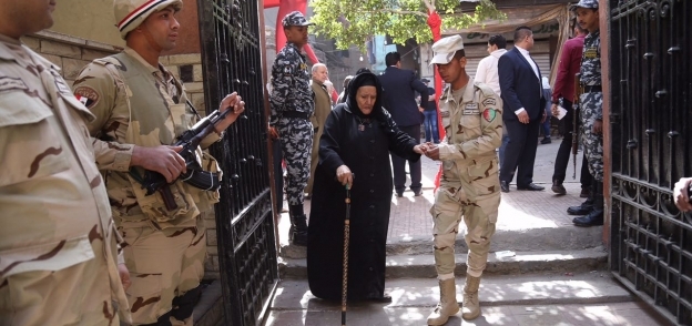 قوات الجيش تساعد إحدى كبار السن في دخول لجنتها الانتخابية