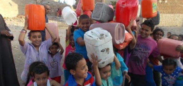 الأطفال يحملون الجراكن لملئ مياه من شركة البترول