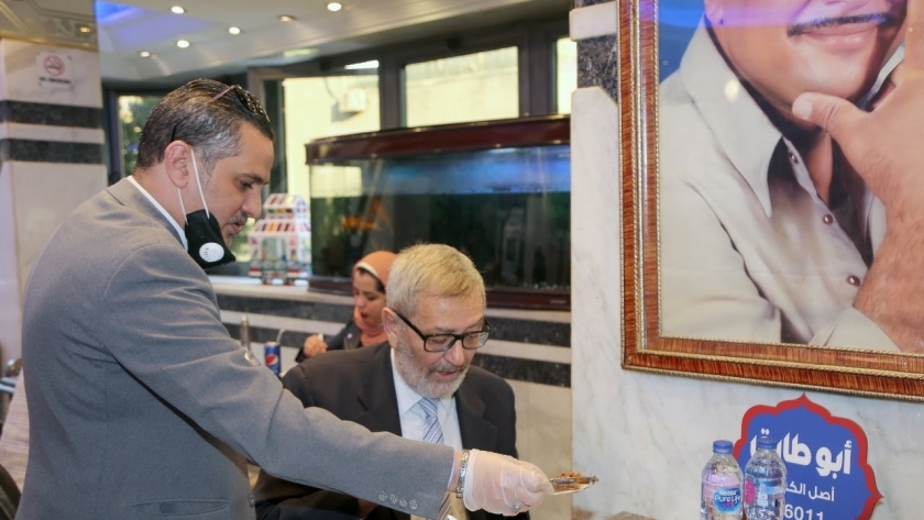 سفير ألبانيا بالقاهرة إدوارد سولو أثناء تناوله الكشرى فى وسط البلد
