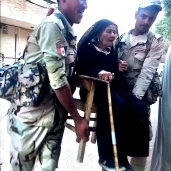 جنديان يحملان عجوزا لمساعدتها على المشاركة بانتخابات الرئاسة