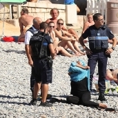 الشرطة الفرنسية تجبر السيدة على خلع "البوركيني"