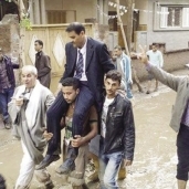 الأمطار تجبر أنصار أحد المرشحين على حمله فى مسيرة انتخابية بالغربية