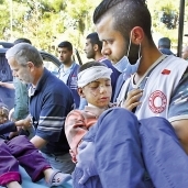 رجال الإسعاف أثناء نقل أطفال سوريين مصابين «أ.ف.ب»