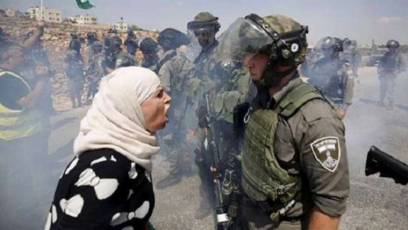 سيدة فلسطينية تقف أمام جنود الاحتلال