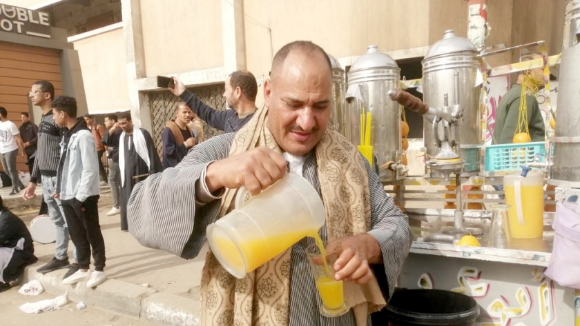 عم محمد يعد عصير البرتقال أمام إحدى اللجان