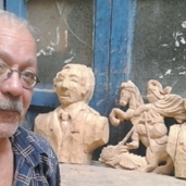 «فوزى» أمام تماثيله الخشبية