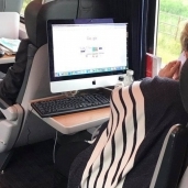 السيدة أثناء استخدامها للكمبيوتر المكتبي في القطار