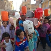 أطفال يحملون «جراكن» لتوفير المياه «صورة أرشيفية»