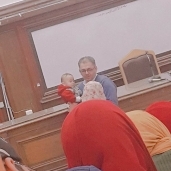 دكتور أحمد عمار وهو يحمل طفل طالبته