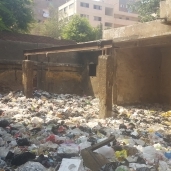 أكوام القمامة بجانب المدرسة ومولد يغذى المنطقة بالكهرباء