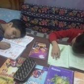 أطفال ينامون أثناء تأدية الواجب المدرسى