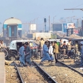مواطنون يعبرون المزلقان بعد مرور أحد القطارات