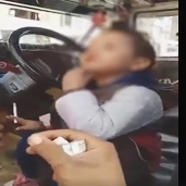 طفل يدخن سيجارة ويمسك بسلاح أبيض