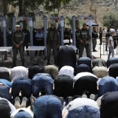 فلسطينيون أثناء أداء الصلاة تحت حواجز وحراسة جيش الاحتلال