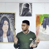 «عبدالرحمن» أمام لوحاته