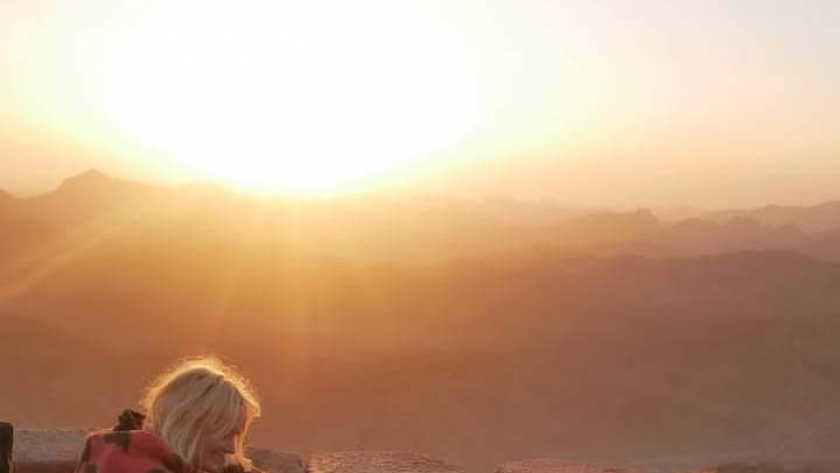 سياح يشاهدون شروق الشمس فوق جبل موسي بسانت كاترين
