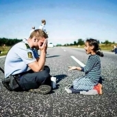 الشرطي الدنماركي يلاعب الفتاة السورية