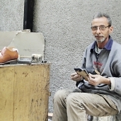 «زعزوع» يصنع أحذية فى ورشة بالشارع