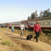 ركاب يحملون أمتعتهم بعد مغادرة القطار فى إحدى المحطات
