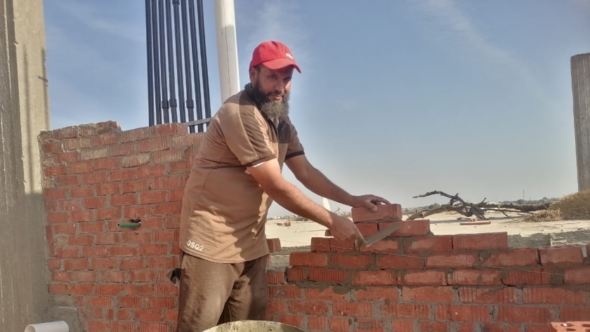 السيد صالح خلال يتلو القرآن الكريم أثناء البناء في دمياط