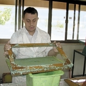 أحد المعاقين المشاركين فى ورشة إعادة تدوير الورق