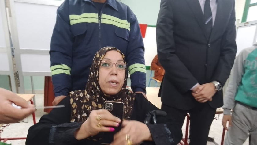 كريمة أثناء الإدلاء بصوتها في لجنة الاقتراع وبرفقتها المسعف