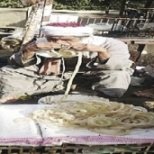 «عم أحمد» أثناء تنظيف «الممبار»