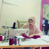 «منار» تعمل على ماكينة الخياطة
