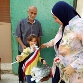 طالبة توزع الورد احتفالًا بنصر أكتوبر بمدرسة بجمرك التعليمية بالإسكندرية