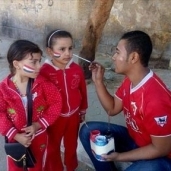 شاب يرسم "علم مصر" على وجوه الأطفال أمام لجان السيدة زينب.. "الرسمة بجنية"