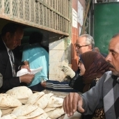 محافظ الإسكندرية أثناء بيعه الخبز لأصحاب البطاقات الورقية