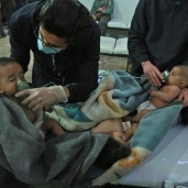 أطباء أثناء إسعاف طفلين سوريين تضررا بسبب قصف «الغوطة»