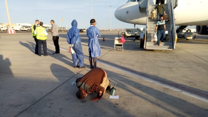 احد العائدين من الخارج يسجد لله شكرا لدى وصوله مطار مرسي علم