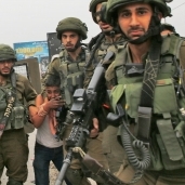 جنود الاحتلال الإسرائيلى أثناء القبض على طفل فلسطينى «أ.ف.ب»