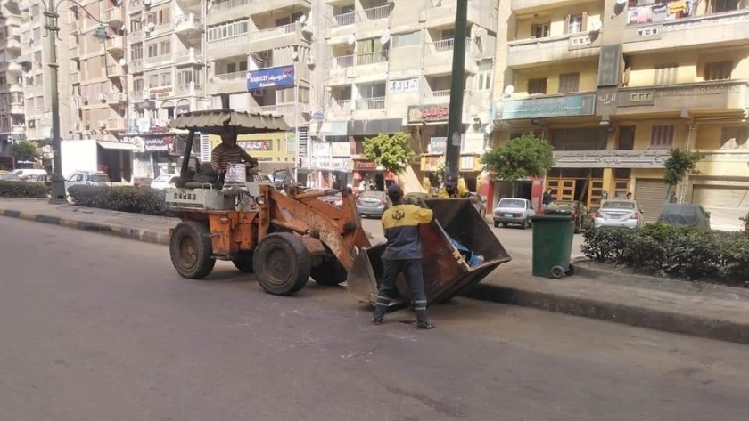 عمال نظافة يؤدون عملهم بأحد شوارع الجيزة