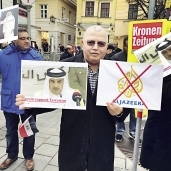 متظاهرون يحملون صوراً تندد بالجزيرة وأمير قطر