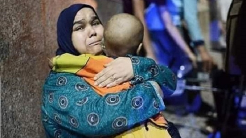 الأم فايزة تحتضن ابنها مريض السرطان أمام معهد الأورام