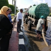 العمال يحاولون شفط مياه الأمطار فى مدينة جمصة
